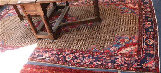 A large Persian red and blue ground carpet, 315cm x 160cm